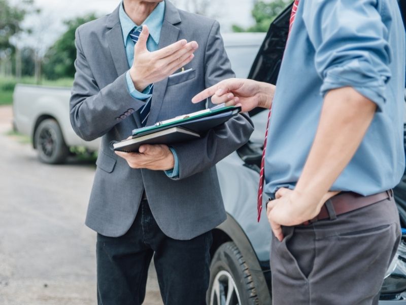 two men in business attire arguing car accident