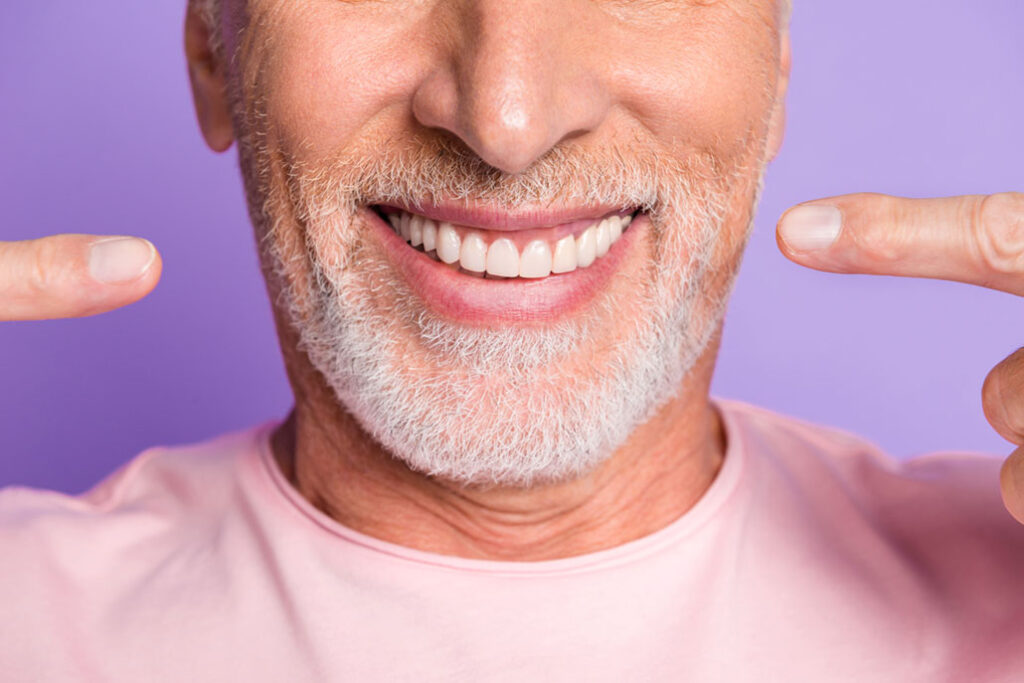 man pointing to his new dental implants